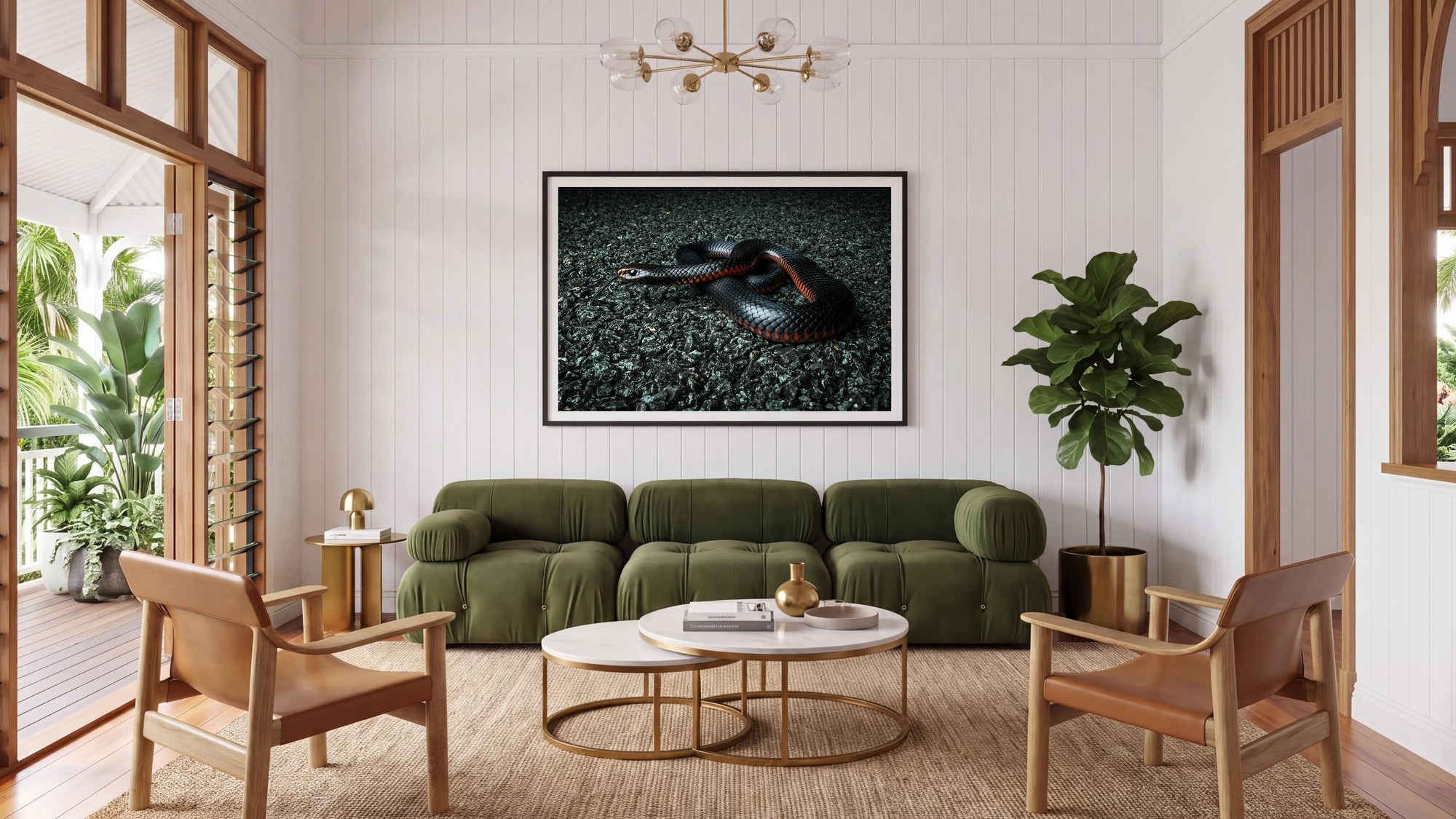A framed wall art print depicting a dark snake on a textured black background, displayed in a modern living room setting above an olive green sofa.